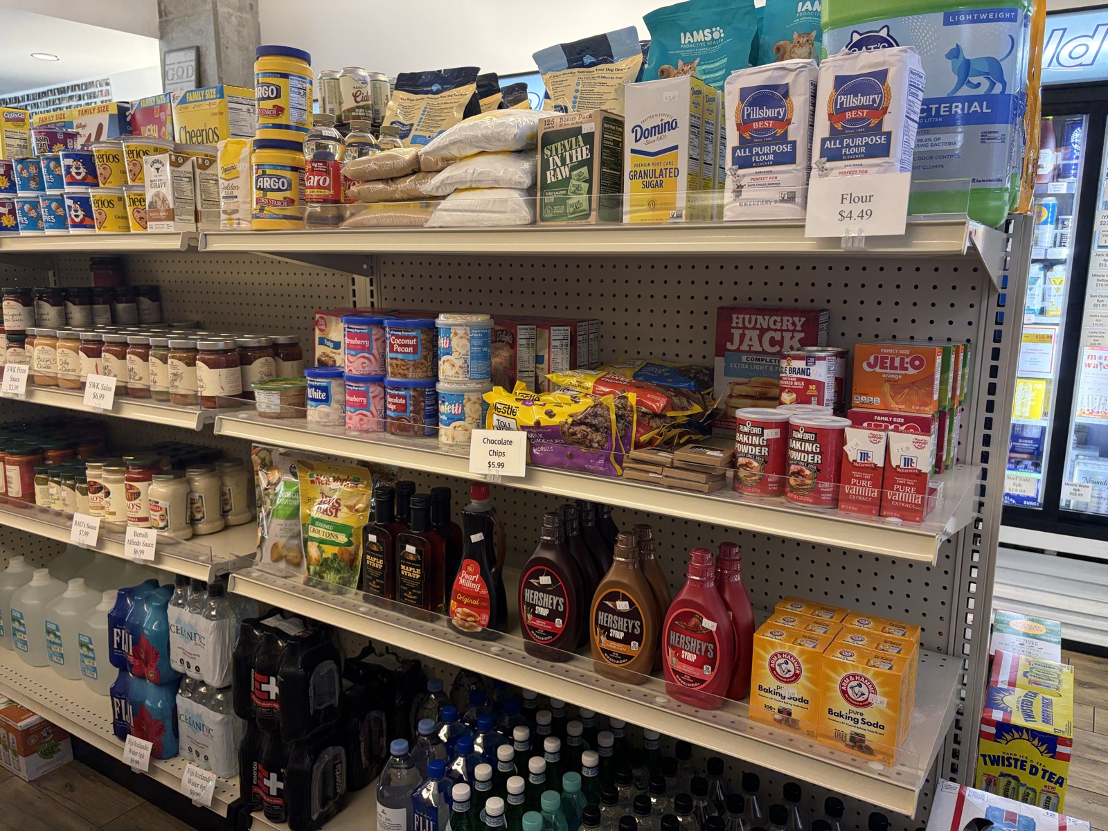Pantry shelves with sauces, syrup, mixes, and baking staples