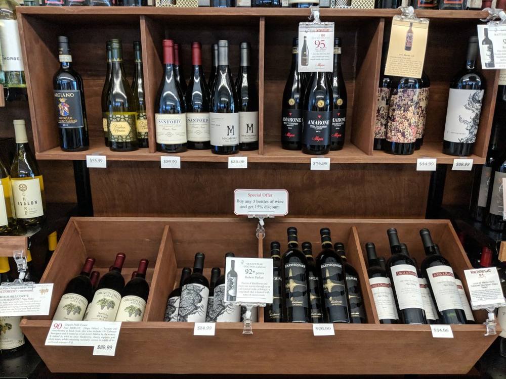 Wine display at The Island Shoppe with a sign offering 15% off any three bottles